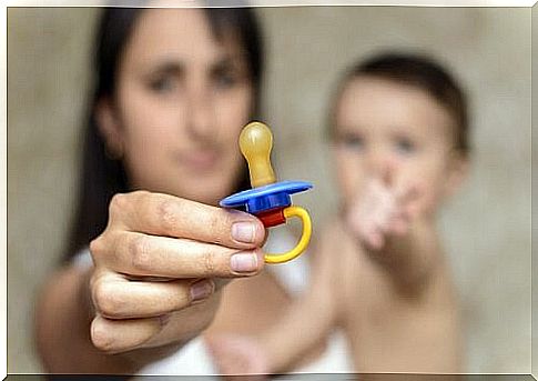 mother taking the baby's pacifier